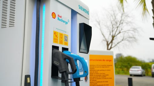 Mano sosteniendo manguera de cargador eléctrico