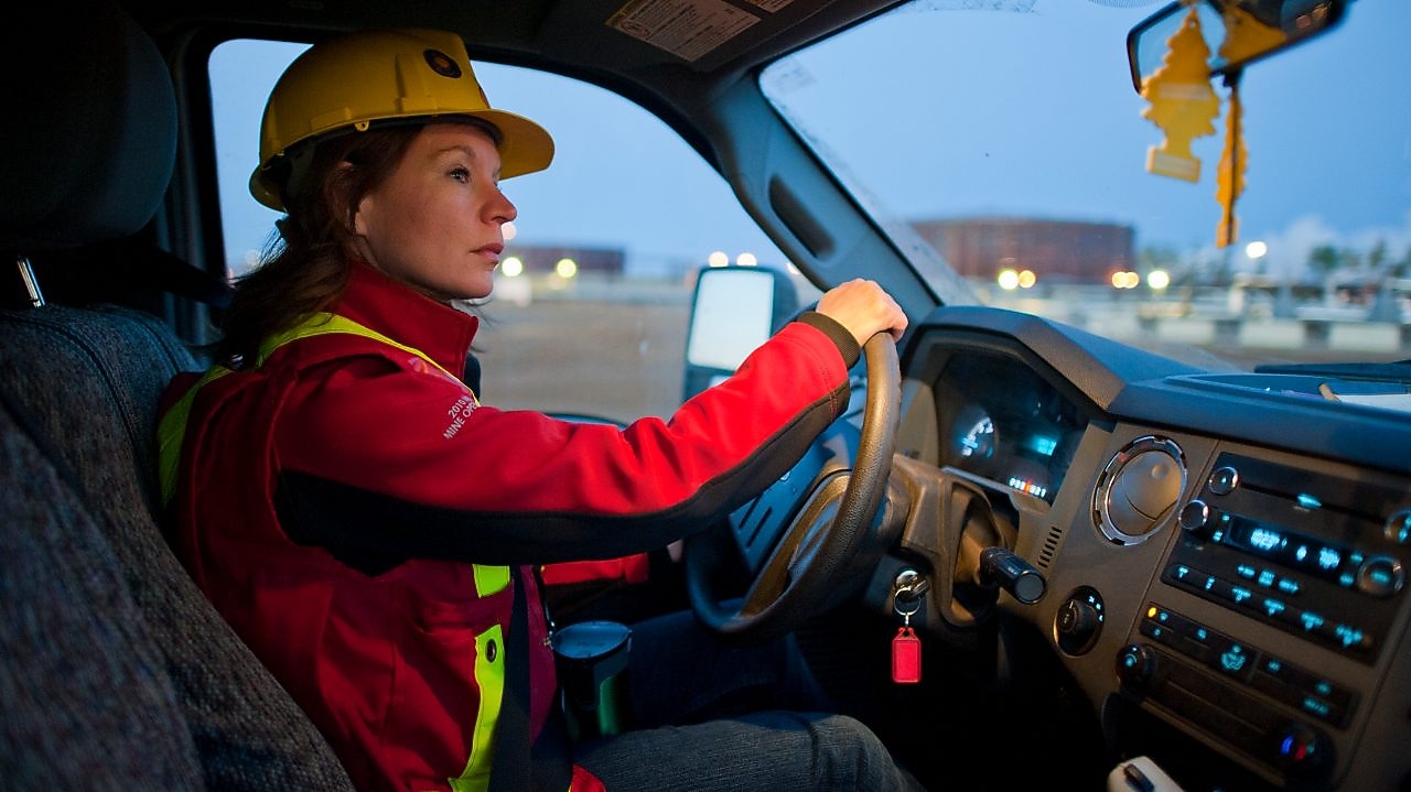 Señora con equipo de seguridad conduciendo un vehículo